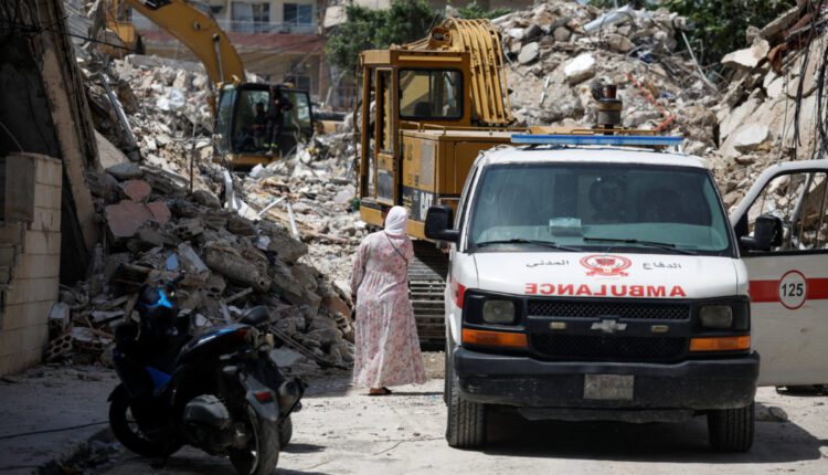 People gather at the site of an Israeli strike carried out before a 10-day ceasefire between Lebanon and Israel went into ...