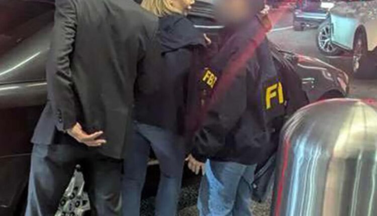 Two individuals wearing FBI jackets engage with a person near a parked car on a city street at night; faces blurred, suggesting a law enforcement interaction.
