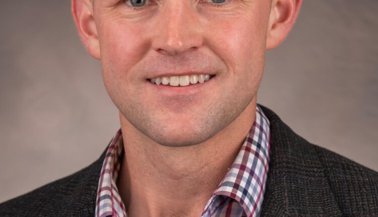 Red “Elon in the News” graphic featuring a professional headshot of a bald man in a blazer and plaid shirt, next to “As featured on WFMY News 2” and the station logo.